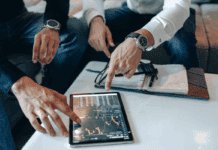 Cryptocurrency Tax Guide and How to Report Crypto Gains Group of people organizing documents and using a laptop to file cryptocurrency taxes
